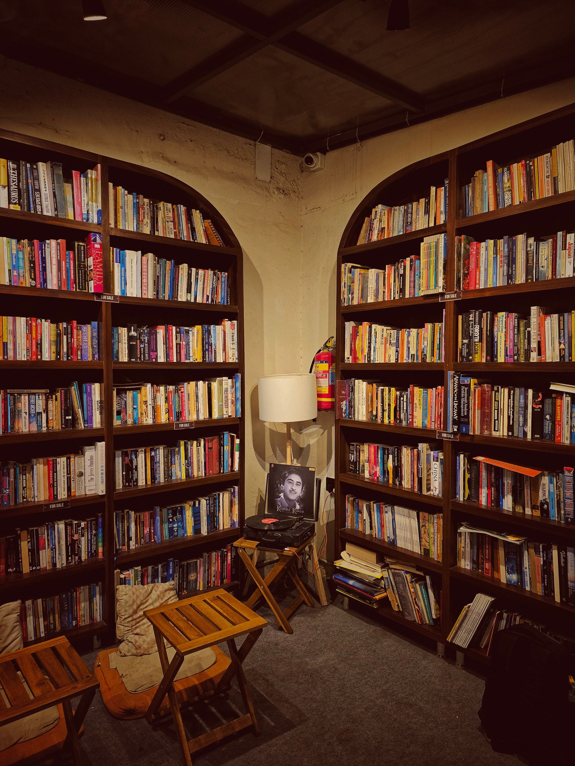 Warm, inviting library corner with wooden bookshelves filled with books and cozy seating.